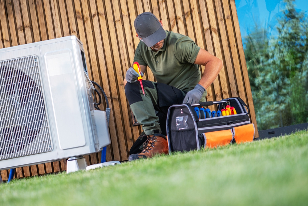 A,Technician,Repairs,An,Air,Conditioning,Unit,Outside,,Meticulously,Organizing